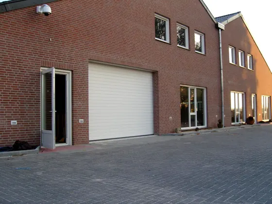 Bakstenen bedrijfspand van Electro Gommans met roldeur
